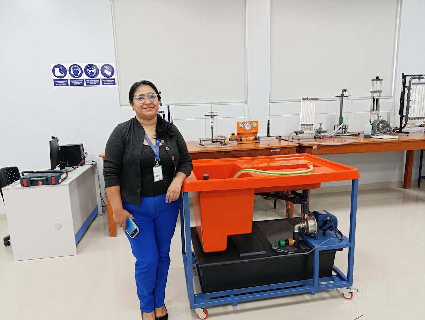 Usuaria de laboratorio junto a un banco hidráulico de la marca INFINIT TECHNOLOGIES, representada en el Perú por ANSELTRONICA.