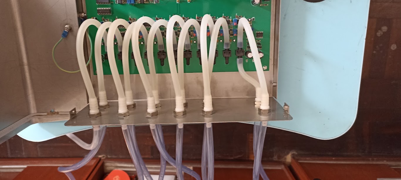 Interior de una consola de control de canal, con tarjeta electrónica, relés y manifold de mangueras, intervenida para su modernización en la UNALM.