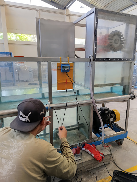 Técnico de ANSELTRONICA verificando una unidad de enseñanza de mecánica de fluidos durante su reparación en el laboratorio.